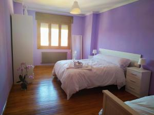 purpurowa sypialnia z łóżkiem i stołem w obiekcie CASA MENCIA w mieście Sober