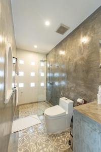 a bathroom with a toilet and a shower at Victory Road Villas in Phong Nha