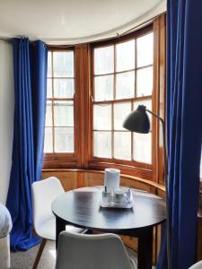 a table with a lamp and chairs in front of a window at Number 75 in Brighton & Hove