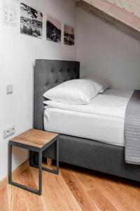 a bed and a table in a room at Small attic rooms in Kaunas old town in Kaunas