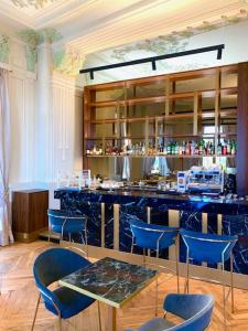 a bar with blue chairs and a table in a room at Lolli Palace Hotel in Sanremo