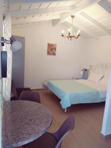 a bedroom with a bed and a table and a chandelier at Villa Anna in Nafpaktos +99 photos
