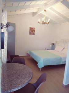 - une chambre avec un lit, une table et un lustre dans l'établissement Villa Anna, à Naupacte
