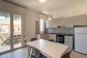 a kitchen with white cabinets and a table and chairs at Residenza Las Vegas in Bellaria-Igea Marina