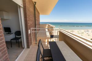 balcón con mesa y sillas y la playa en Residenza Las Vegas en Bellaria-Igea Marina