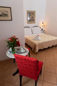 a room with a table, chairs, and a vase of flowers at Dei Mori in Florence