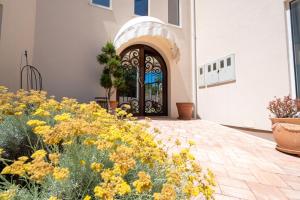 a front door of a house with yellow flowers at Villa Art gallery apartments in Murter