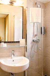 a bathroom with a sink and a shower at Arkade Hotel am Theater in Heilbronn