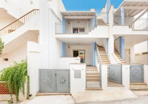 a white house with blue doors and stairs at Villetta Verdi a Pescoluse in Marina di Pescoluse