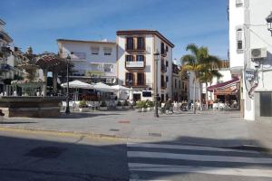a city street with tables and chairs and buildings at Ático by Alhaurín Loft City Center in Alhaurín de la Torre