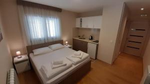 una camera con un grande letto e una piccola cucina di Pilon apartments a Žabljak