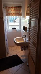ein Bad mit einem Waschbecken und einem Fenster in der Unterkunft Ferienwohnung Petersen in Nordstrand