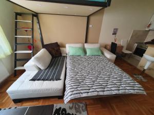 Cette chambre comprend un grand lit et un canapé blanc. dans l'établissement Stankovic apartman, à Niš