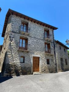 - un grand bâtiment en pierre avec une porte et des fenêtres en bois dans l'établissement CASA PEDRO BERGUA, à Fiscal