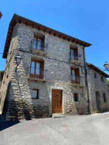 un gran edificio de piedra con puertas y ventanas de madera en CASA PEDRO BERGUA, en Fiscal