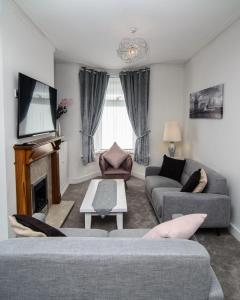 a living room with a couch and a fireplace at RIVERPOOL - LUXRY SUITS FOR FOOTBALL FANS NEAR AnFIELD STADIUM in Liverpool