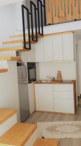 a small kitchen with white cabinets and a staircase at Cattleya's Loft in Veliko Tŭrnovo