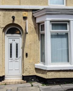 a building with a white door and a window at RIVERPOOL - LUXRY SUITS FOR FOOTBALL FANS NEAR AnFIELD STADIUM in Liverpool