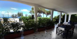 eine Terrasse mit Tischen und Pflanzen und Meerblick in der Unterkunft VILLA AZZURRA beachfront Mondello - Palermo in Palermo