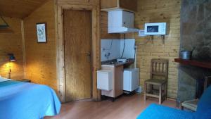 a room with a kitchen and a stove in a cabin at Cabañas La Toma del Agua in Riópar +10 photos