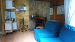 a living room with a blue couch and a fireplace at Cabañas La Toma del Agua in Riópar