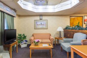 克拉克斯維爾的住宿－克拉克斯維爾伊克諾套房旅館，一间设有椅子、电视和桌子的等候室