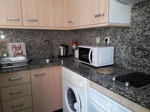 a kitchen with a stove top oven and a microwave at Apartamento Confortable En Ciudad in Tarragona