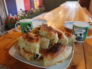 dos pasteles en un plato en una mesa con dos tazas en Kamp Janketic en Kolašin