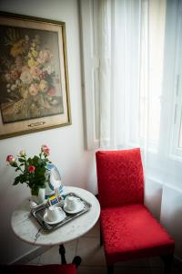 a red chair and a table with a vase of flowers at Dei Mori in Florence
