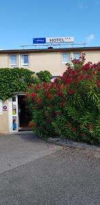 a hotel with red flowers in front of a building at The Originals City, Hôtel Valence Est in Valence +28 photos