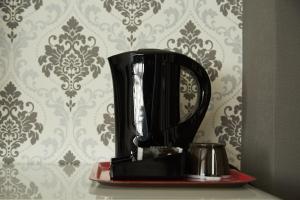 una macchinetta del caffè nera su una mensola di fronte a un muro di Focus Boutique a Courtrai
