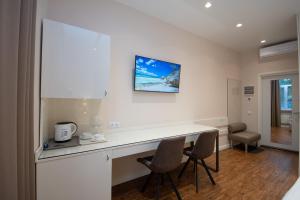 a kitchen with a white counter and two chairs at Современный минимализм в центре Киева. in Kyiv