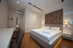 a bedroom with a large white bed and a desk at Современный минимализм в центре Киева. in Kyiv
