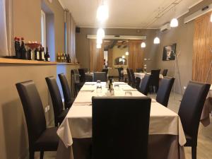 um restaurante com uma longa mesa com mesas e cadeiras brancas em Locanda Penaceto em Longare