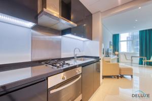 a kitchen with a sink and a stove at Prim Studio at The Cosmopolitan Business Bay by Deluxe Holiday Homes in Dubai