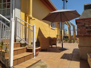 a patio with an umbrella next to a building at CASA PARDAIÑA in Vigo