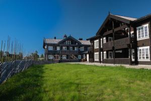duży dom z zielonym trawnikiem przed nim w obiekcie Blefjell Lodge w mieście Lampeland