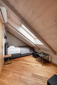 an attic bedroom with a bed and a table at Small attic rooms in Kaunas old town in Kaunas