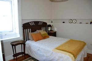 a bedroom with a bed with orange pillows and a window at Quinta D'Avó Amélia in Alquerubim