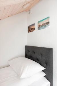 ein Schlafzimmer mit einem weißen Bett mit zwei Bildern an der Wand in der Unterkunft Small attic rooms in Kaunas old town in Kaunas