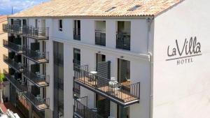 a white building with balconies and a hotel at Hôtel La Villa Port d'Antibes & Spa in Antibes