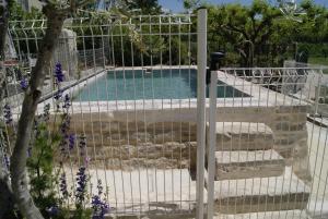 a gate leading to a swimming pool in a garden at Gîte en Provence ''Rose'' in Modène