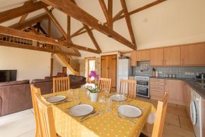 eine Küche und ein Esszimmer mit einem Tisch und Stühlen in der Unterkunft The Oaks - Ash Farm Cotswolds in Stow on the Wold