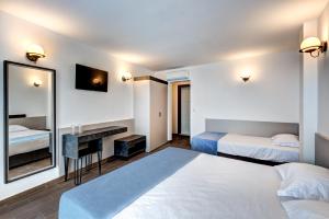 ネセバルにあるPanorama Blue Family Hotel and Free parkingのベッドが2つと鏡があるホテルの部屋