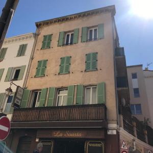 ein Gebäude mit grünen Fensterläden auf einer Straße in der Unterkunft Résidence Le Suquet in Cannes