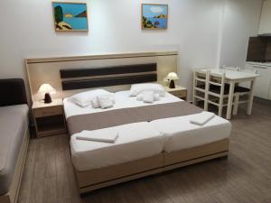 a bedroom with a large bed and a kitchen at Hotel Katerina in Keramoti