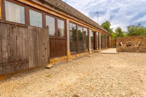 ストウ・オン・ザ・ウォルドにあるThe Fold - Ash Farm Cotswoldsの木製のドアと窓のある納屋