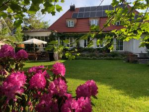 uma casa com flores cor-de-rosa no quintal em München- Pullach, Wohnen im Grünen em Pullach im Isartal