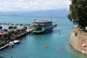 a cruise ship docked at a dock in the water at Hotel Bell'arrivo by Dori in Peschiera del Garda