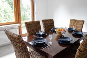 a dining room table with chairs and a table with a bowl of fruit at Panorama Lodge Hohegeiß Sport und Erholung im Harz in Braunlage
